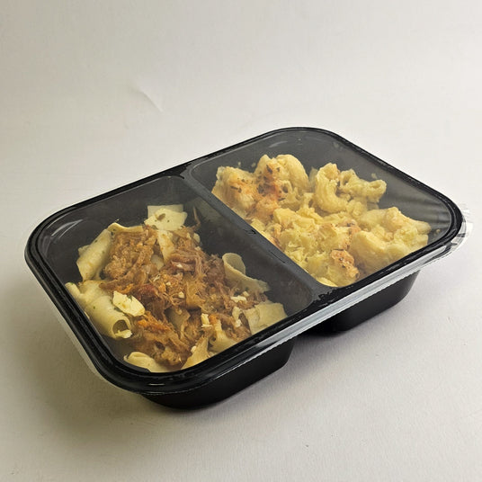 Two compartments of pasta with different toppings in a black plastic container on a white background