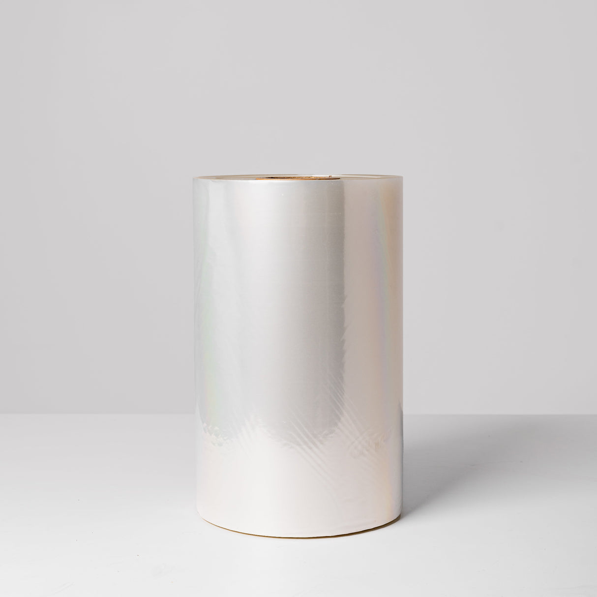 A roll of clear, high clarity lidding film, standing upright against a light background.