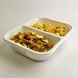 Two compartments of food in a white container on a light gray background