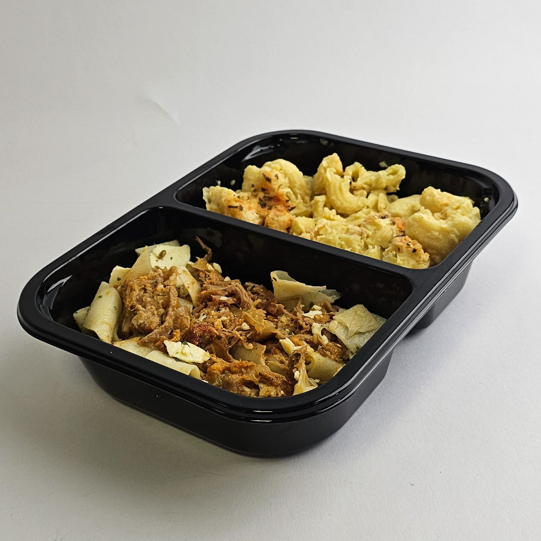 Black plastic container with two compartments of pasta and vegetables on a white background