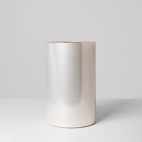 A roll of clear, high clarity lidding film, standing upright against a light background.