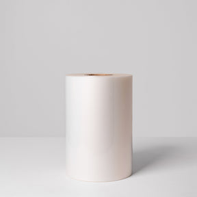 A roll of white, high-barrier lidding film made from wood pulp cellulose, displayed against a neutral background.