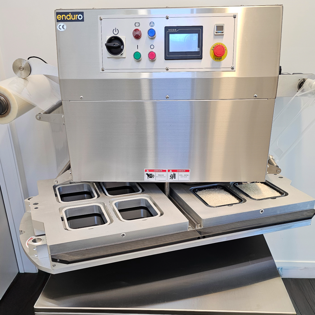 Stainless steel machine with control panel and compartments on a white background