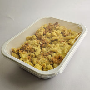 Macaroni and cheese in a white container on a light gray background